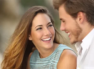 male and female clients with radiant white dental veneers smiling.