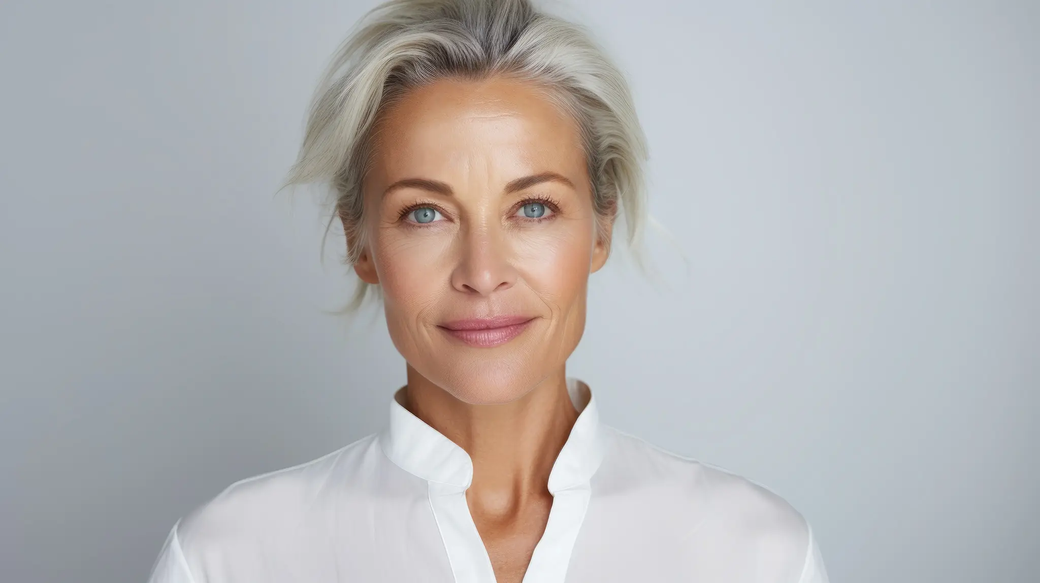 image of a attractive grey haired woman with a wrinkle-free, smooth neck which would be the desired effect following neck lift surgery.