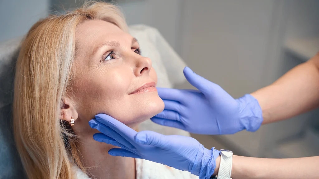 Woman having her face and neck assessed during a facelift consultation