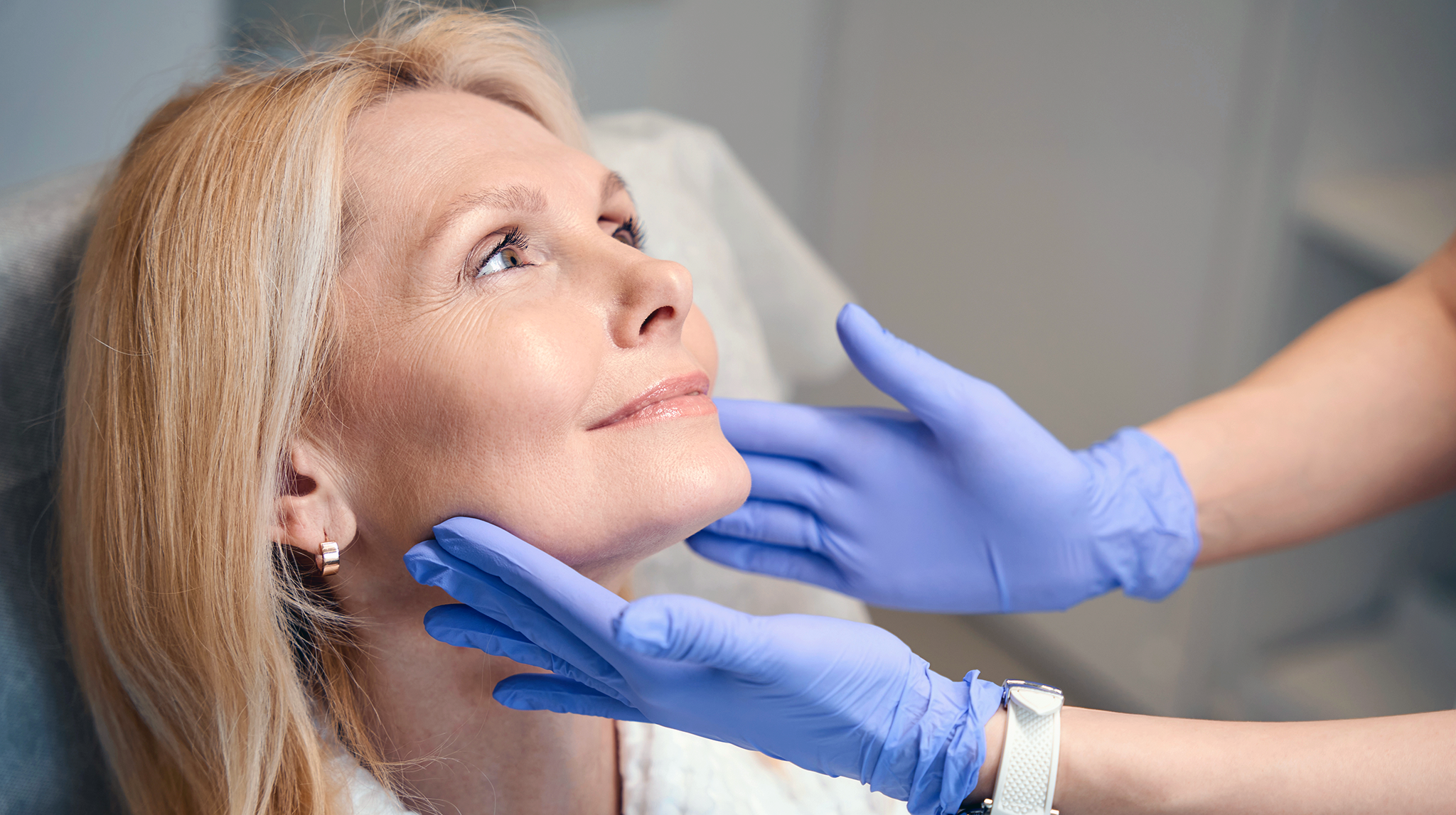 Woman having her face and neck assessed during a facelift consultation